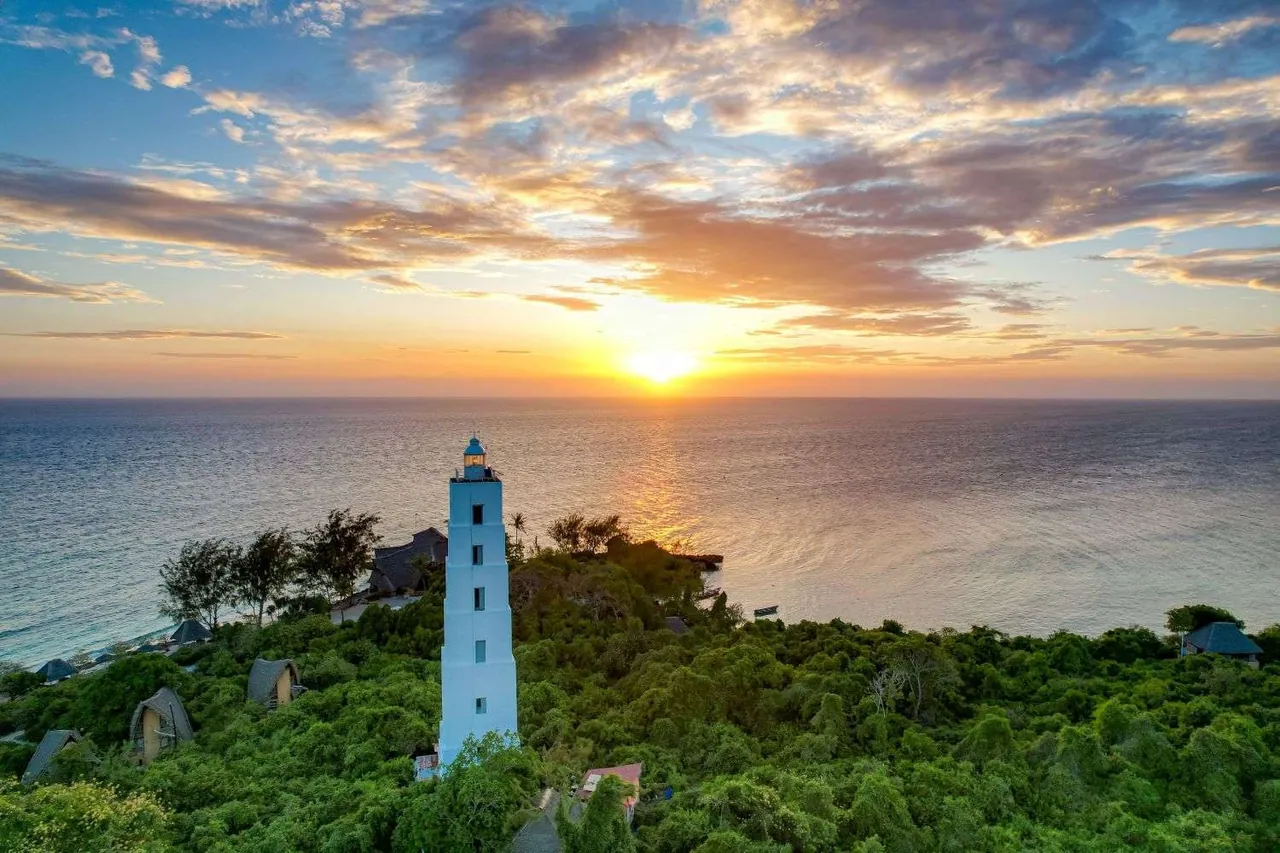 Chumbe lighthouse silhouetted at sunset above the forest