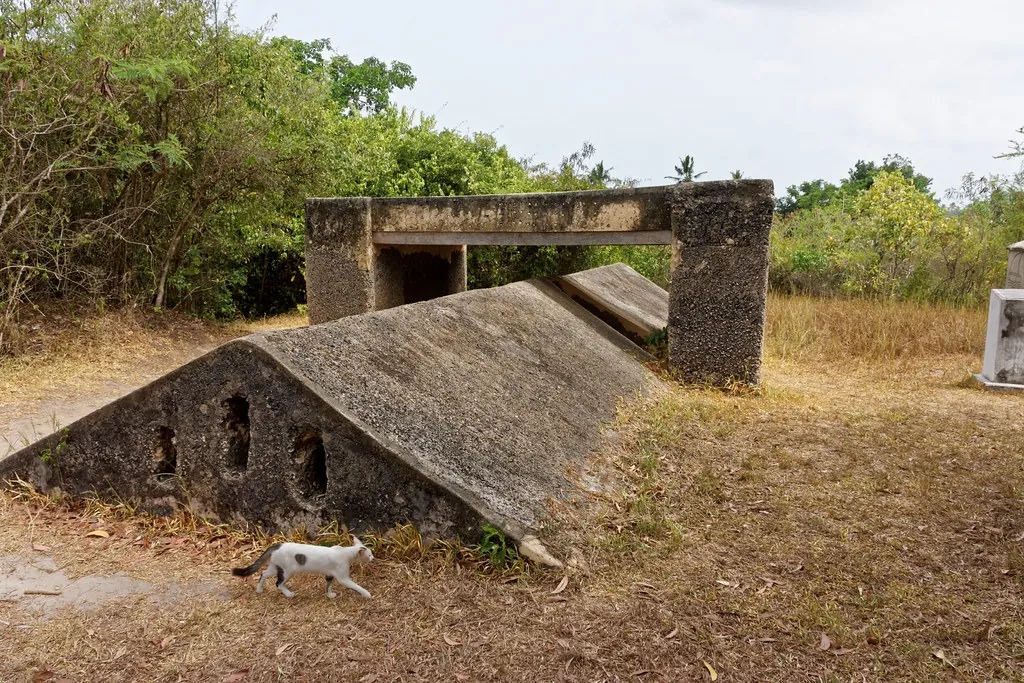 Low stone roof of an underground chamber with a doorway structure in dry grass