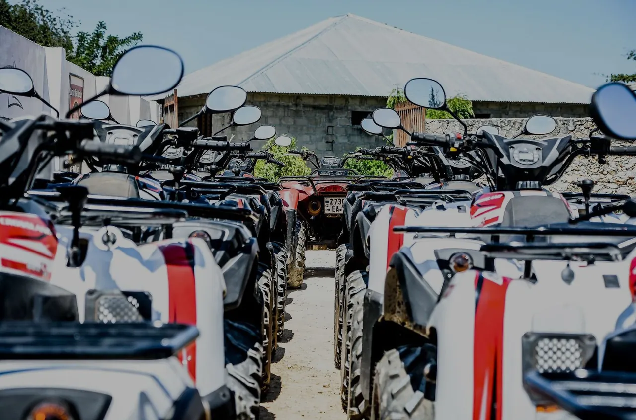 Row of parked white and red quad bikes in front of a building