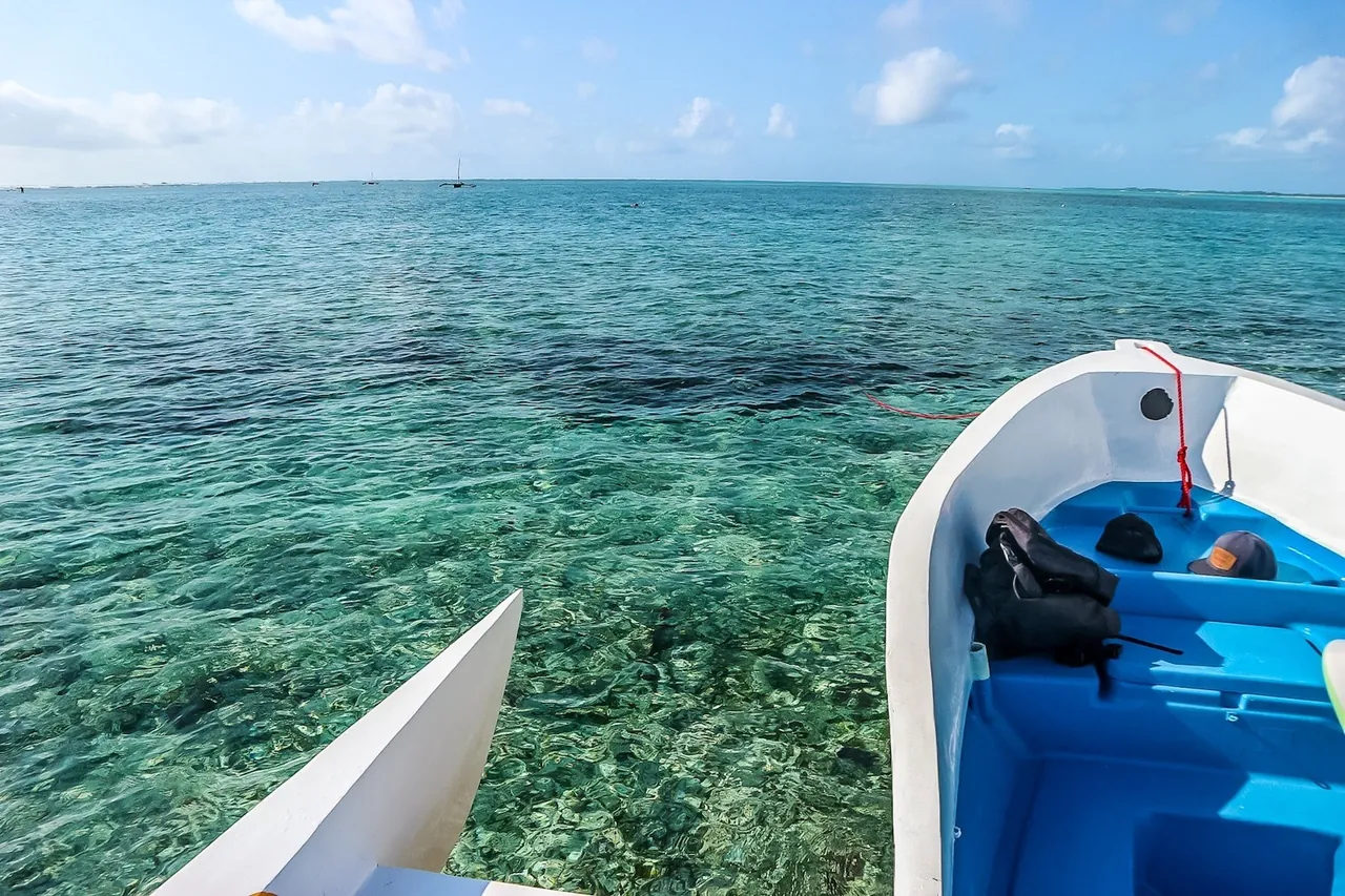 View from a small boat over clear shallow water and coral reef
