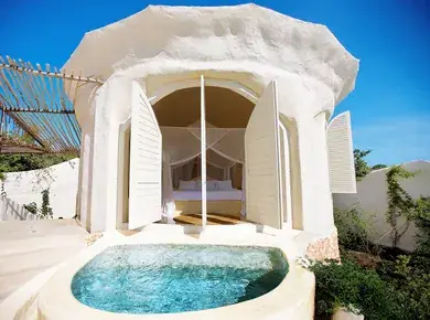 A white domed pavilion with open shutters behind its private plunge pool