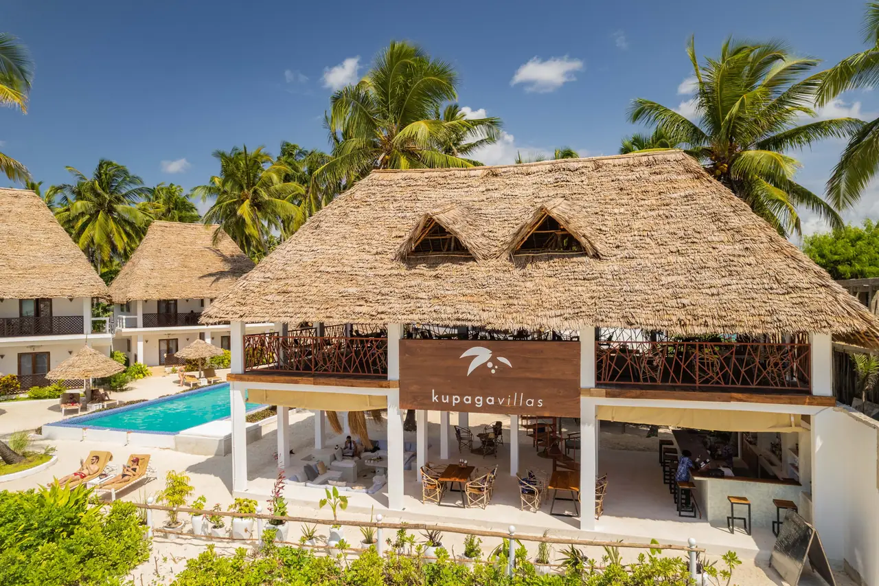 The thatched restaurant building beside the pool among palms