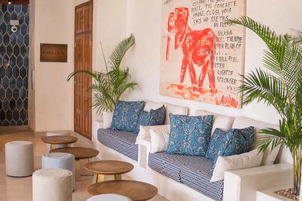 A lounge with blue cushions and a painted elephant artwork
