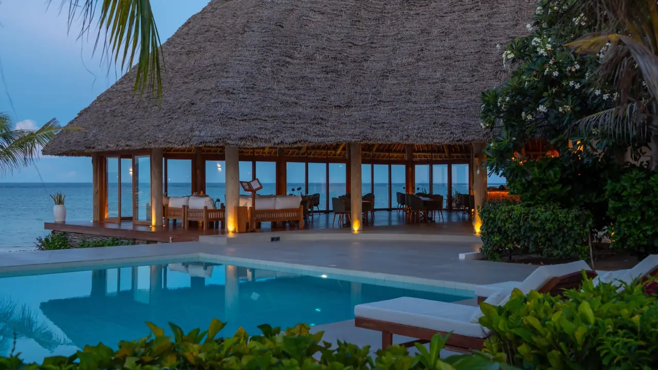 A thatched restaurant beside the pool on the beach
