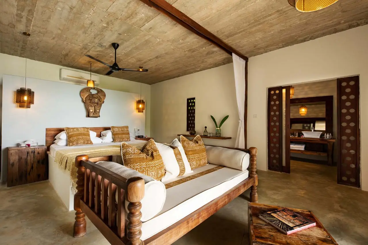 A bedroom with a carved wooden bed and a ceiling fan