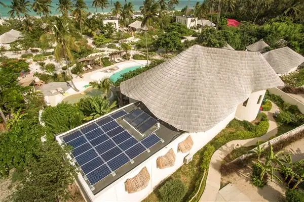 Solar panels on a thatched roof among the gardens