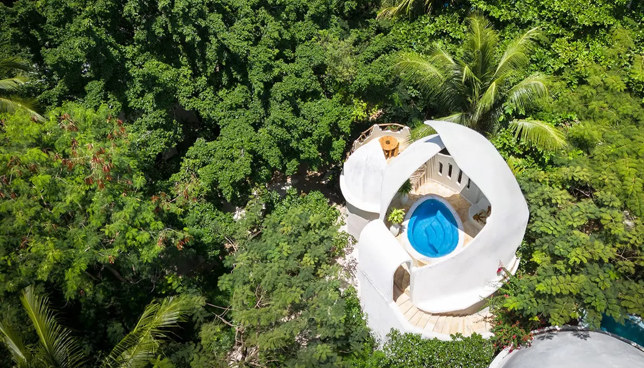 A sculptural white rooftop with a circular pool, seen from above