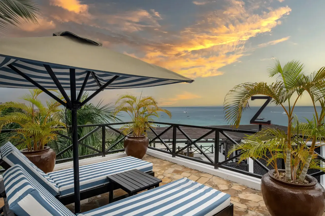 A rooftop terrace with striped loungers at sunset