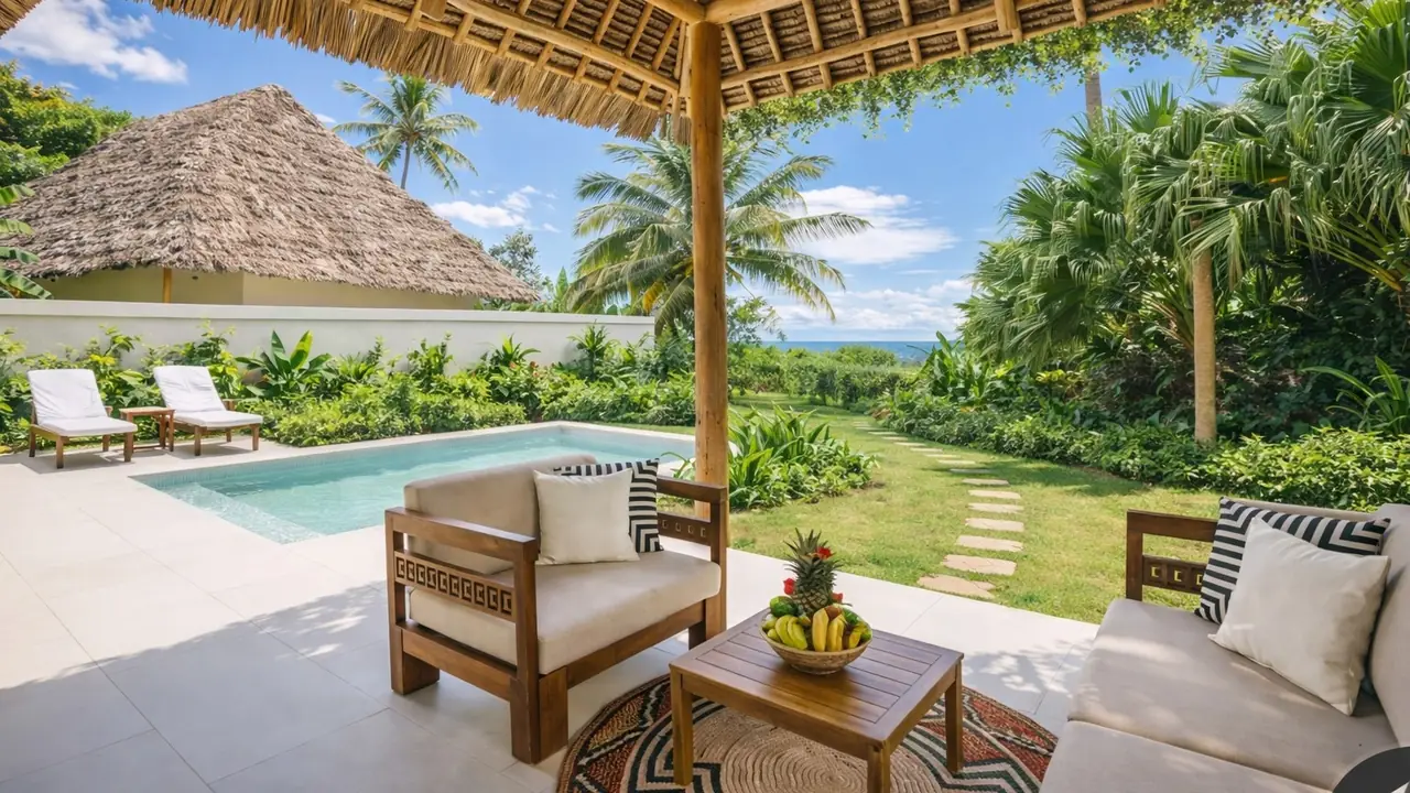 A villa terrace with armchairs and a private pool in a garden