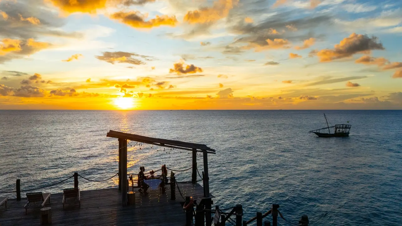 The sun setting over the sea, seen from a wooden deck