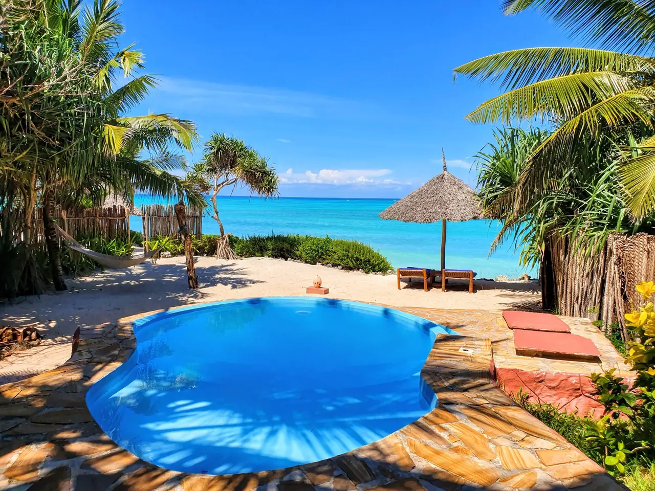 A free-form pool on a stone terrace overlooking the turquoise sea