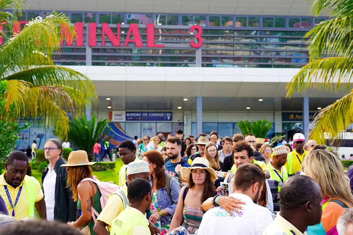 Crowd of arriving passengers and airport staff outside Terminal 3 at Zanzibar airport