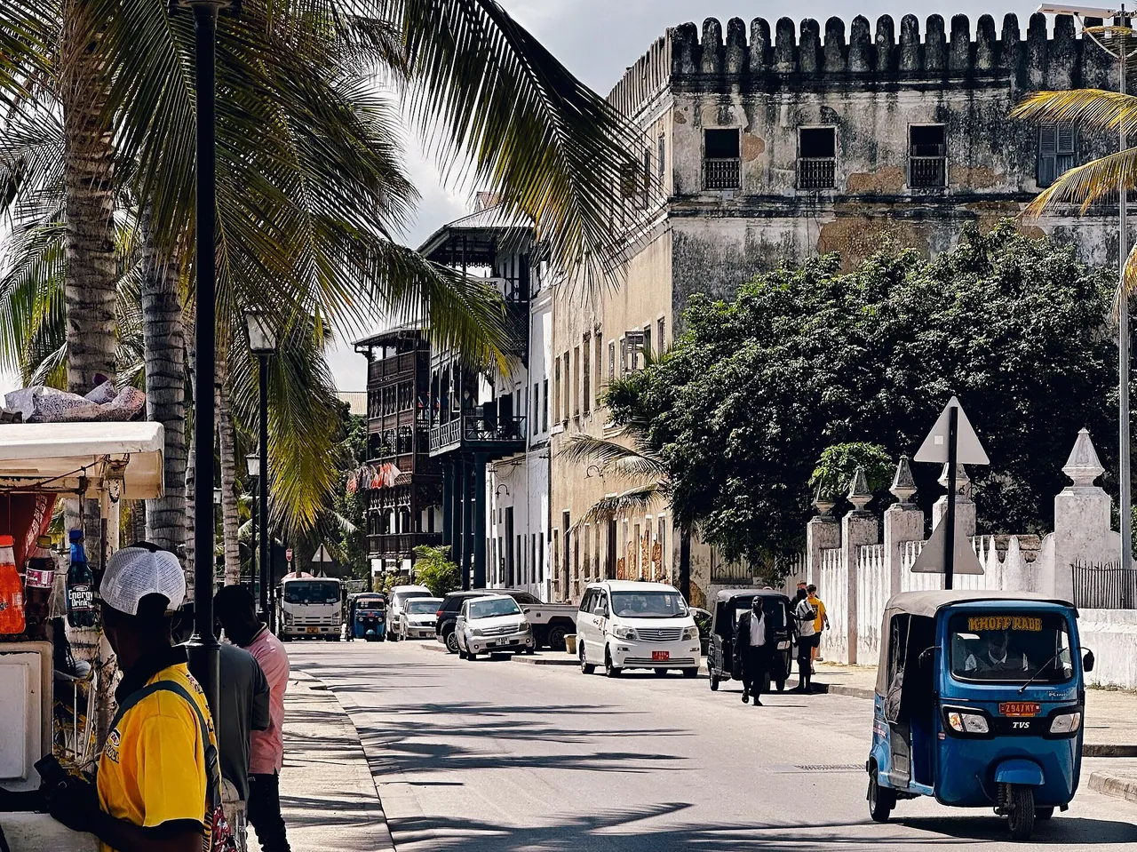 Blue bajaji on a Stone Town street lined with old buildings