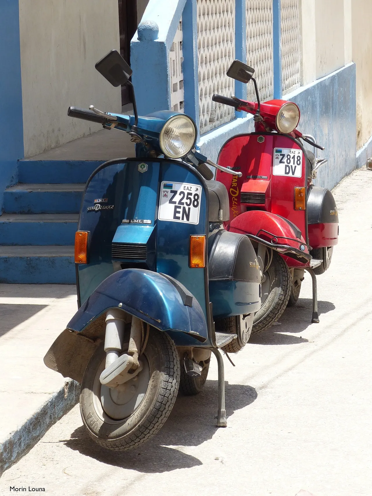 Two parked scooters, blue and red, with Zanzibar "Z" number plates