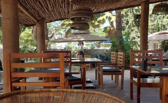 Shaded café seating with wooden tables