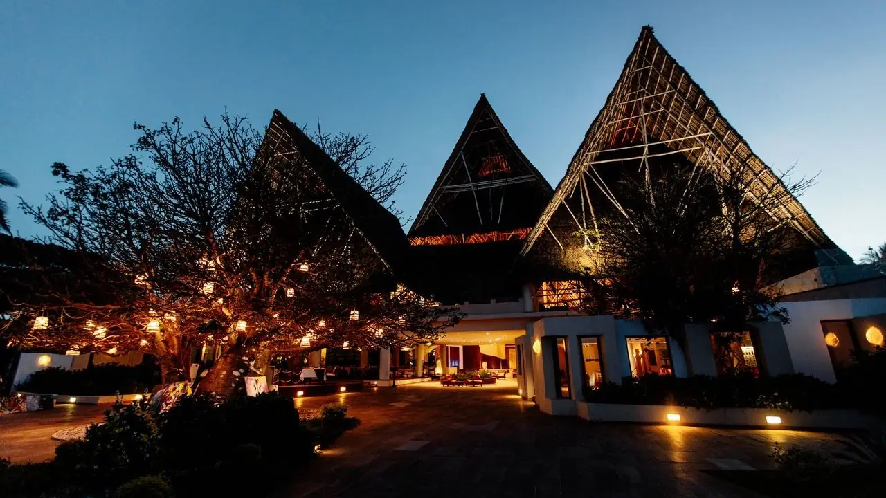 The tall thatched main building lit up at night