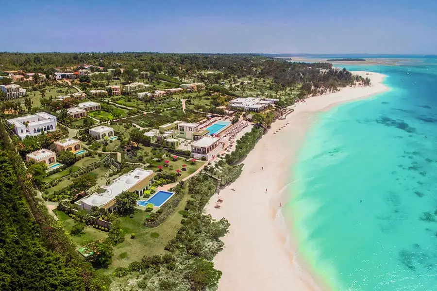 Aerial view of the resort grounds running down to a long curving beach