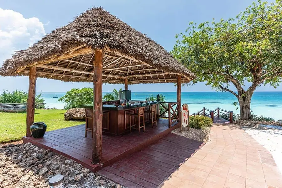 A thatched beach bar on a timber deck beside the sea