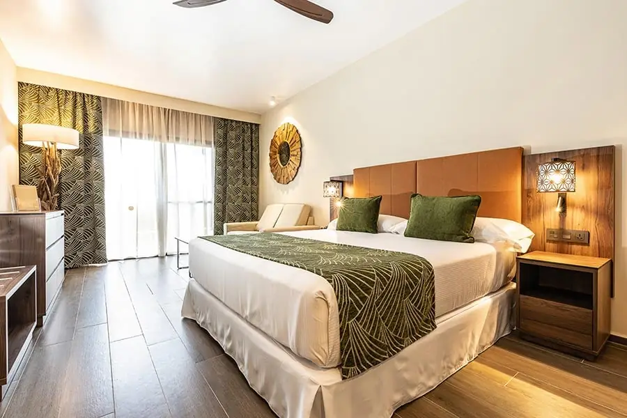 A suite bedroom with a large bed and patterned throw