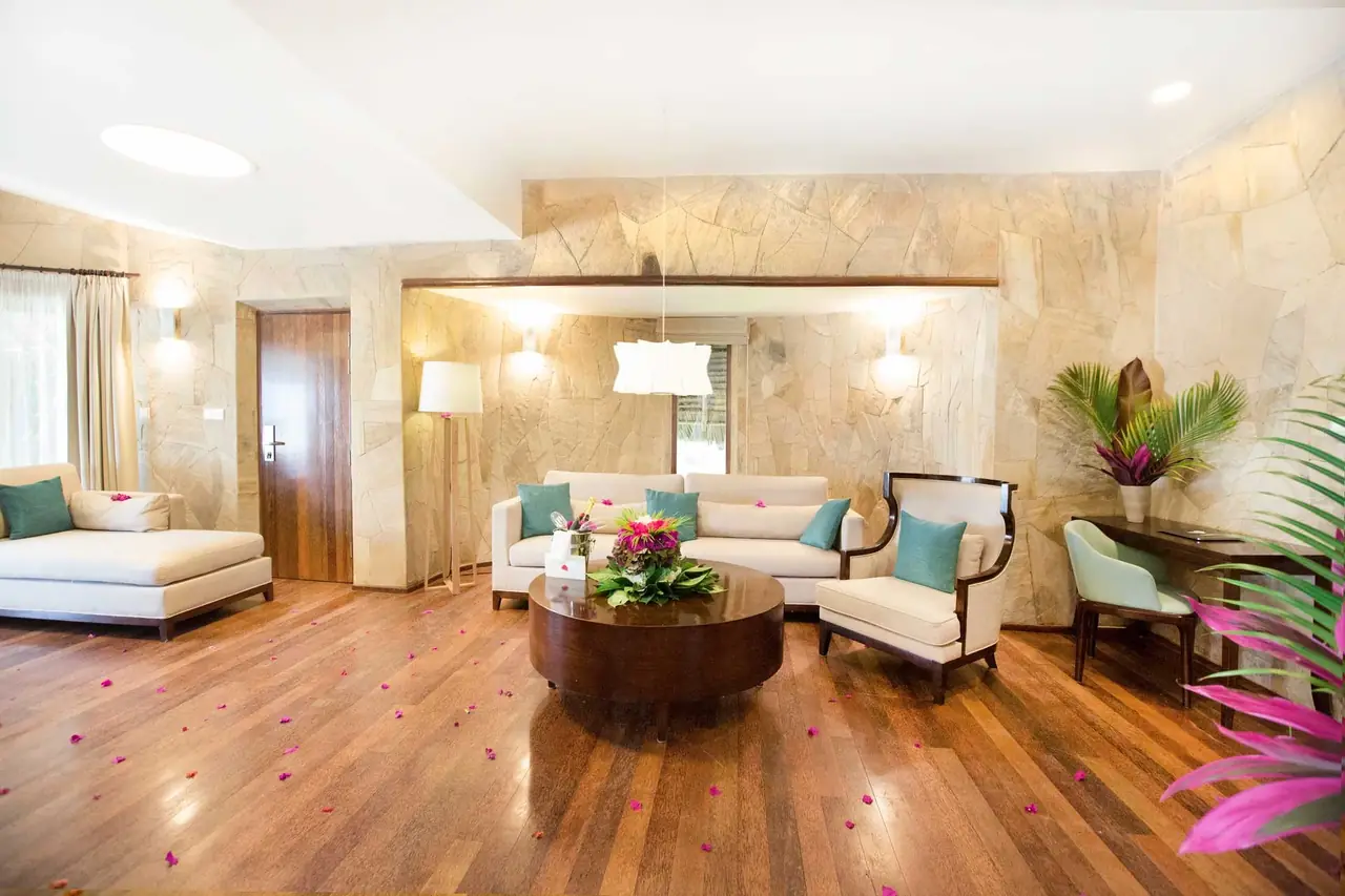 A living room with sofas, wooden floors and stone walls