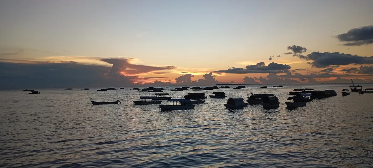 The sun setting over the Zanzibar Channel with boats at anchor, seen from the Forodhani seafront