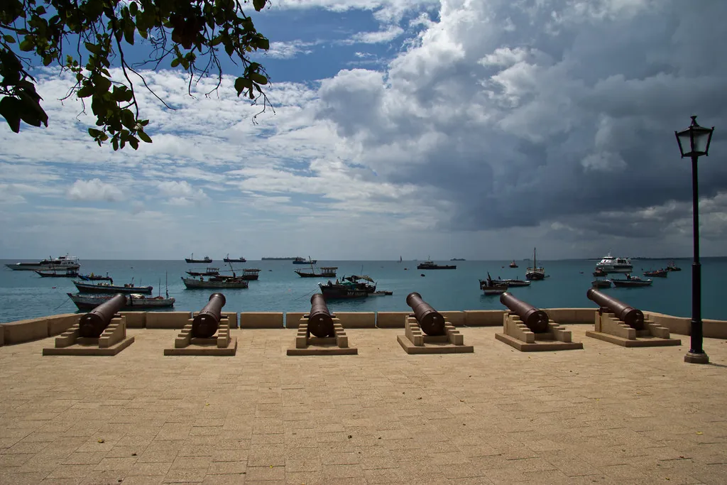 A row of old cannons on the paved Forodhani seafront looking out over the anchorage