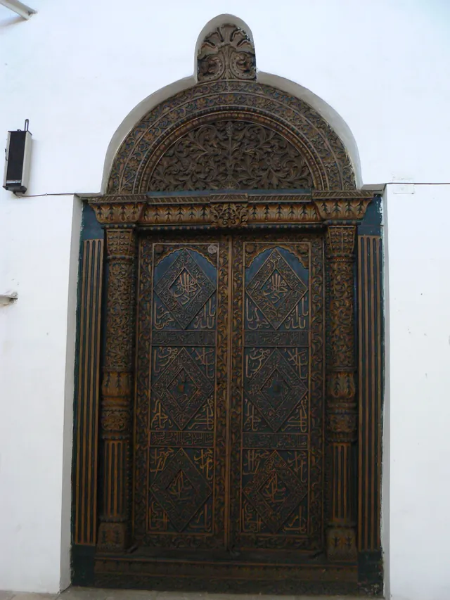 A carved wooden Zanzibari door in a white wall