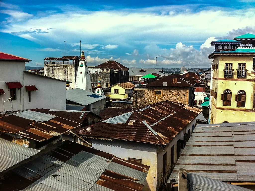 Rust-red corrugated roofs, minaret and old houses of Stone Town under a dramatic sky