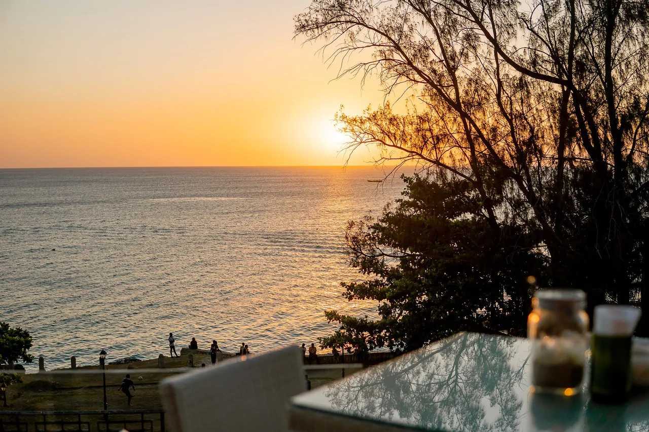 The sun setting over the Indian Ocean seen from a terrace table above the Shangani shore
