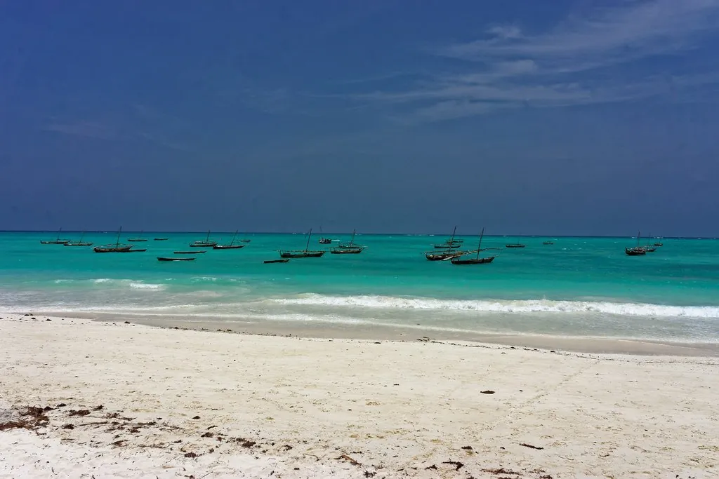 Fishing dhows moored off a white-sand beach in turquoise water