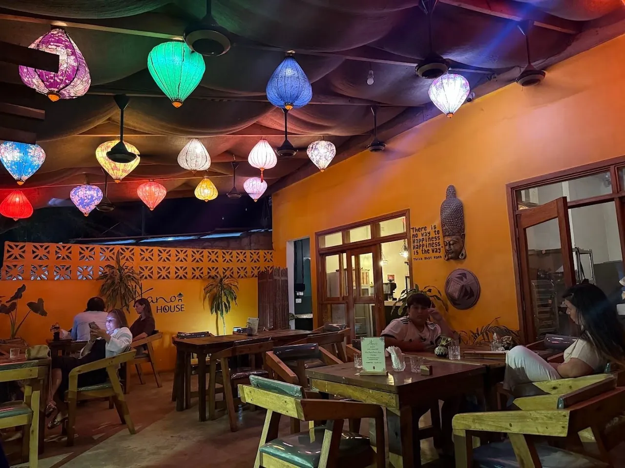 The orange dining room in the evening under colourful silk lanterns
