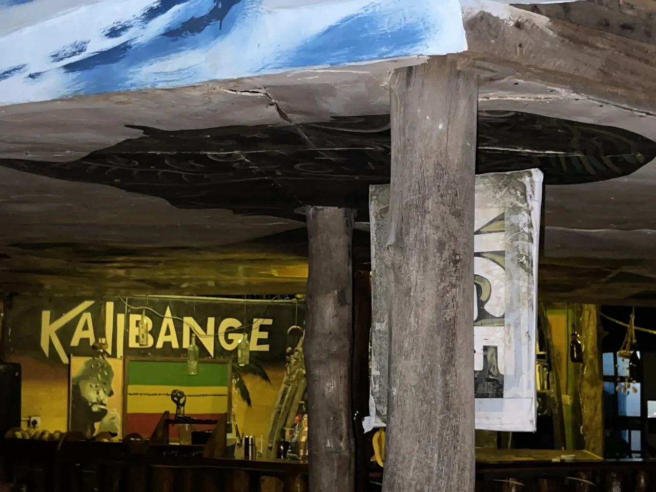 The Kajibange bar sign in Rasta colours under a timber roof